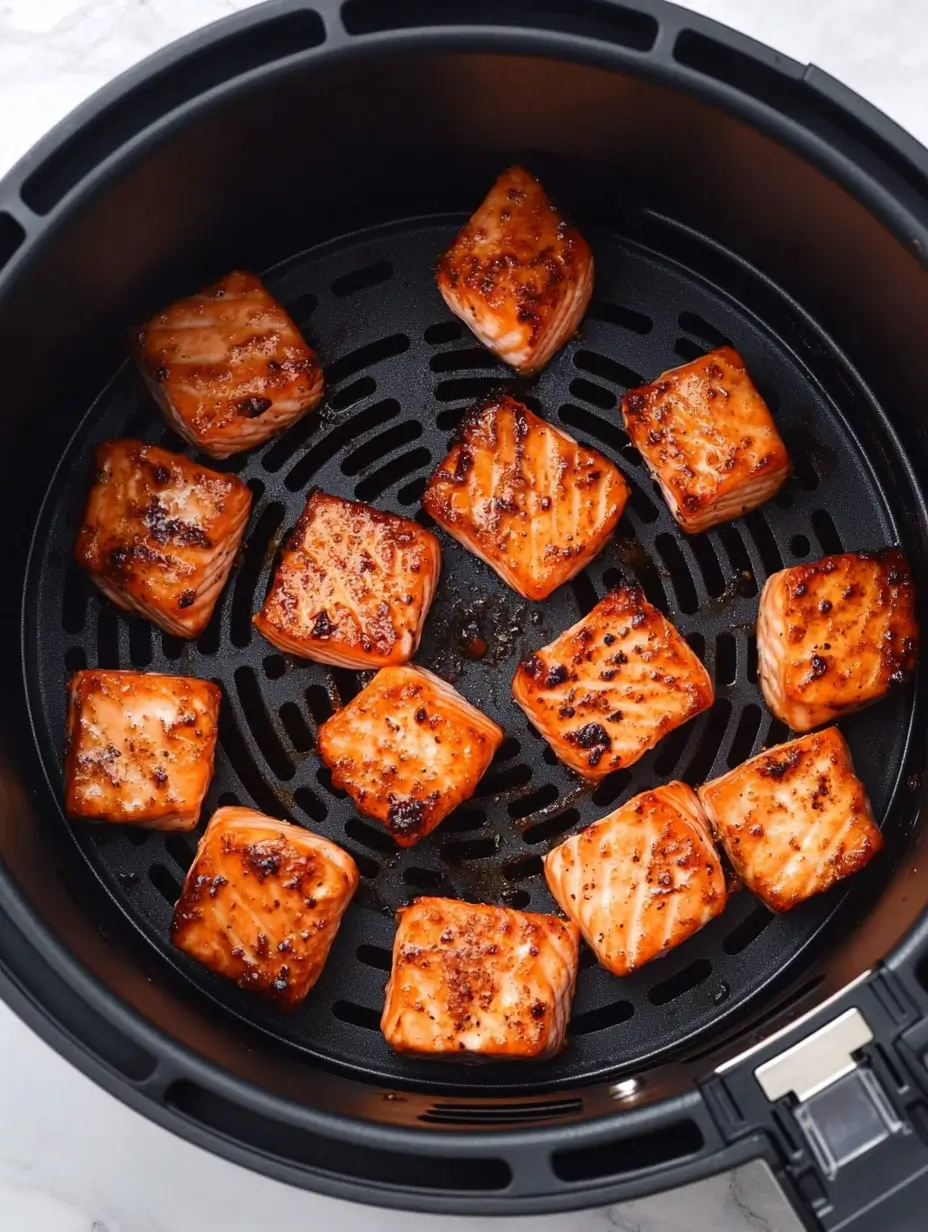 Salmon Bites in The Air Fryer 5 Golden-brown evenly cooked in an air fryer basket.