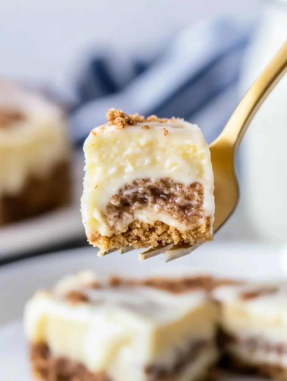 CINNAMON ROLL CHEESECAKE 9 Golden-fork-lifting-a-bite-of-cinnamon-roll-cheesecake-with-graham-crust