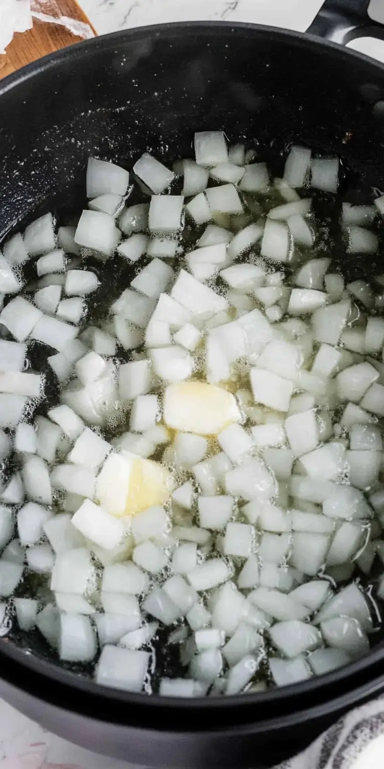 4 Ingredient Potato Soup 14 Diced-onions-sautéing-in-butter-inside-a-black-pot