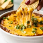 Chili Cheese Dip Recipe 18 hand-dipping-tortilla-chip-into-gooey-cheesy-chili-dip