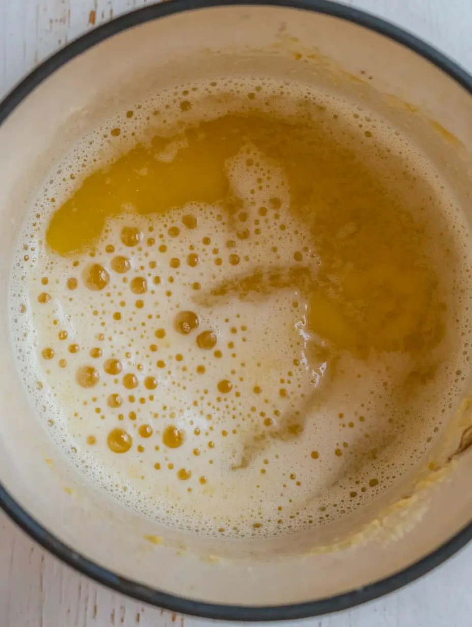 SEAFOOD BOIL SAUCE RECIPE 3 Melted butter in a pot, bubbling slightly with foam forming on the surface.