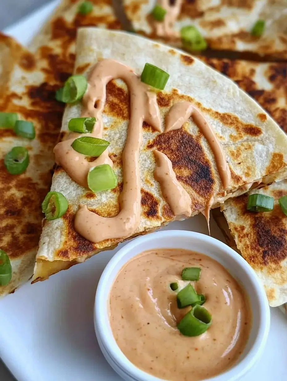 Steak Quesadilla Recipe You Can Whip Up Anytime 3 A close-up of steak quesadilla with drizzled creamy sauce and chopped green onions.