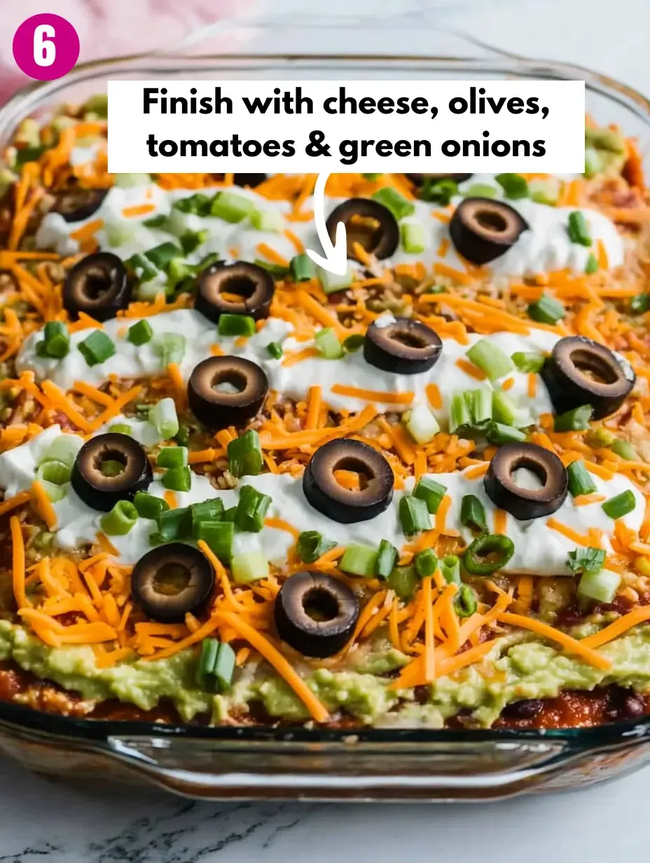 The BEST 7-Layer Bean Dip Recipe 17 Finish-with-cheese-olives-tomatoes-green-onions