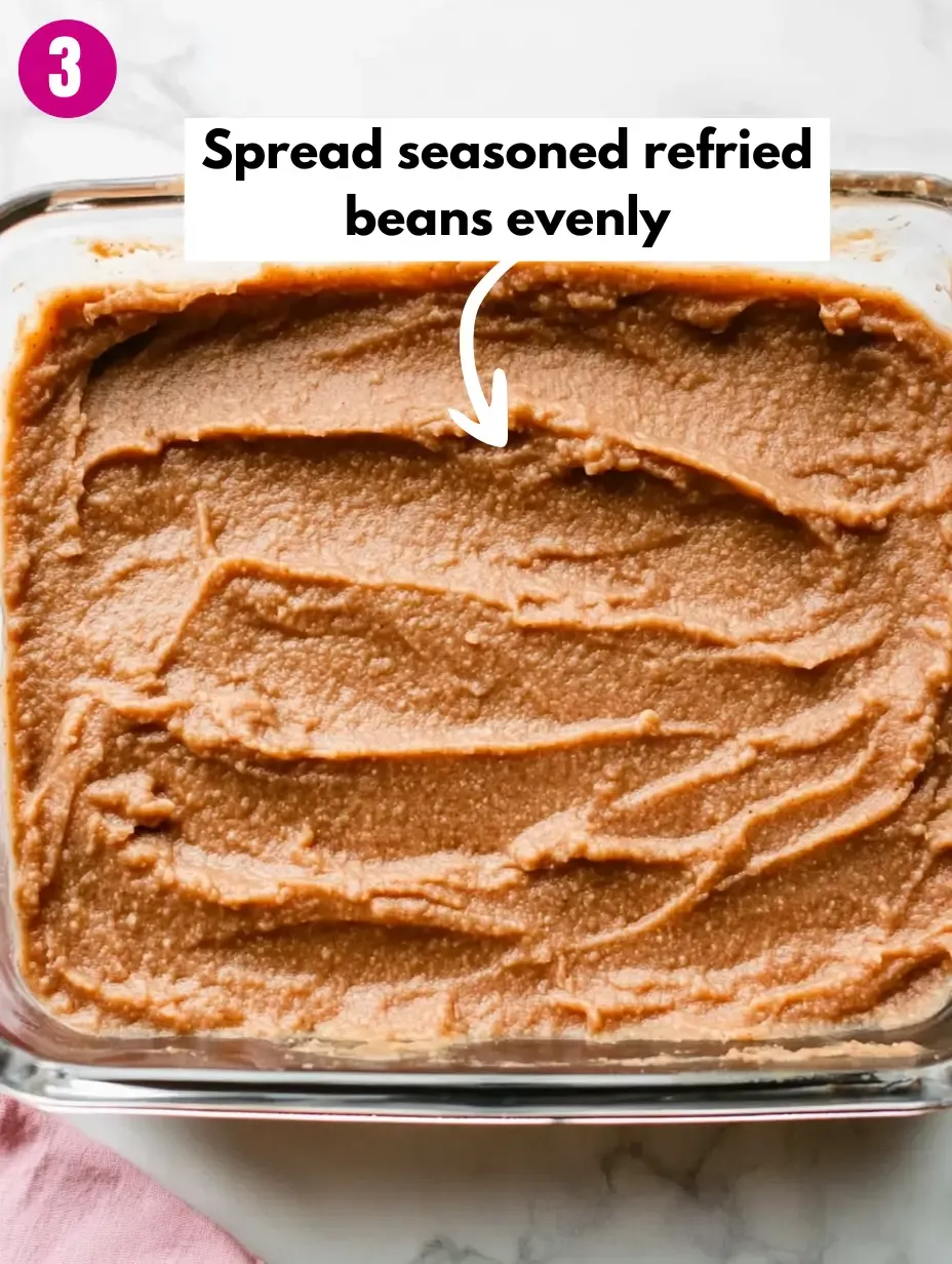 The BEST 7-Layer Bean Dip Recipe 14 Spread-seasoned-refried-beans-evenly