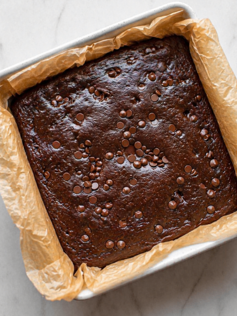 freshly baked cottage cheese brownies in pan with glossy melted chocolate chips, just out of the oven