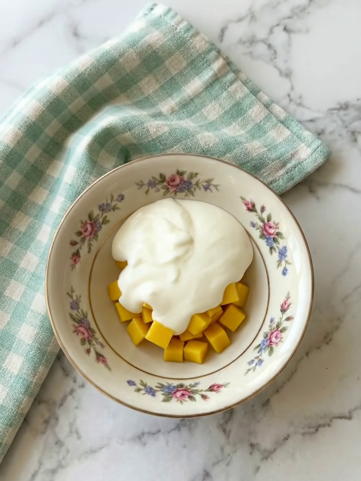 Bowl with thick Greek yogurt and fresh mango cubes before mixing, showing the two main ingredients in Chocolate Mango Yogurt Bites