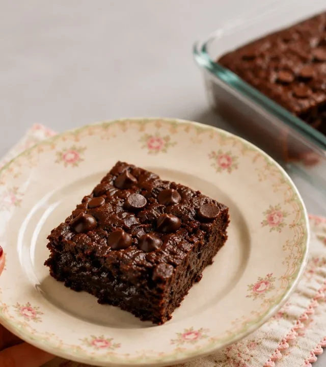 High Protein Fudgy Banana Brownie square on a floral plate with the baking dish in the background