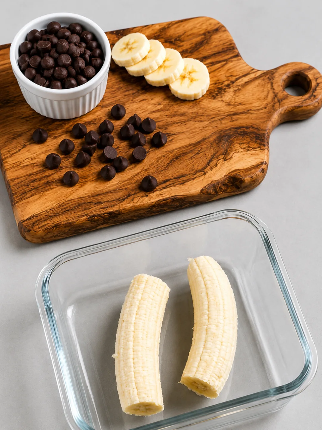 High Protein Fudgy Banana Brownie 1 Chocolate chips banana slices and two banana halves in a glass dish for high protein banana brownie