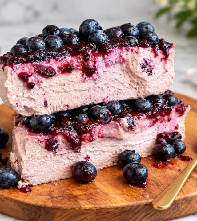stacked-slices-of-high-protein-blueberry-cheesecake-with-a-gold-spoon